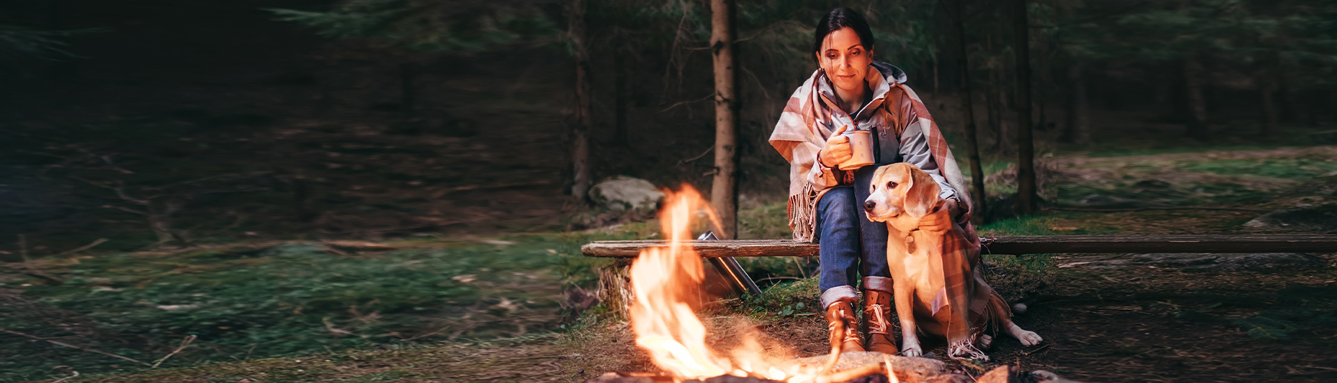 lady with dog sitting by a fire